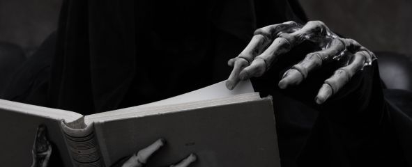 manos de esqueleto sujetando libro