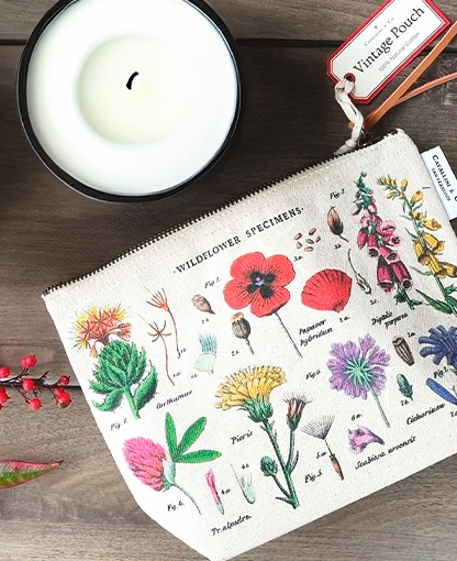 Bolso de mano de flores sobre mesa con vela
