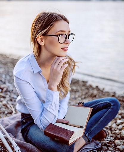 chica con un libro sentada en la playa